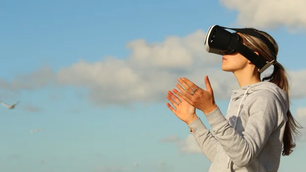 Young woman looking through VR headset.
