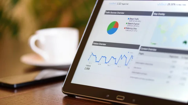 Laptop screen showing Google analytics page with coffee cup in the background
