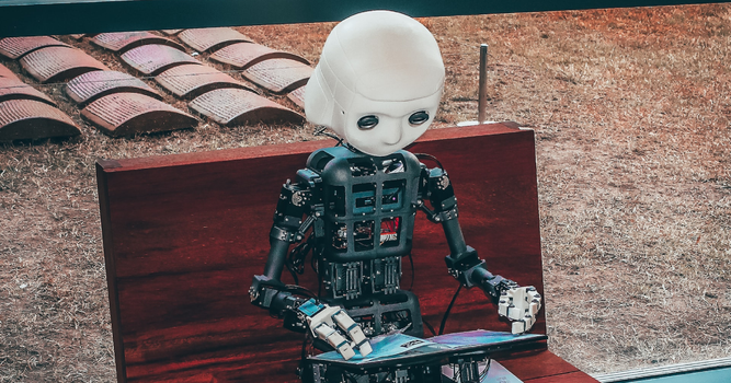 A robot sitting on a park bench reading a magazine